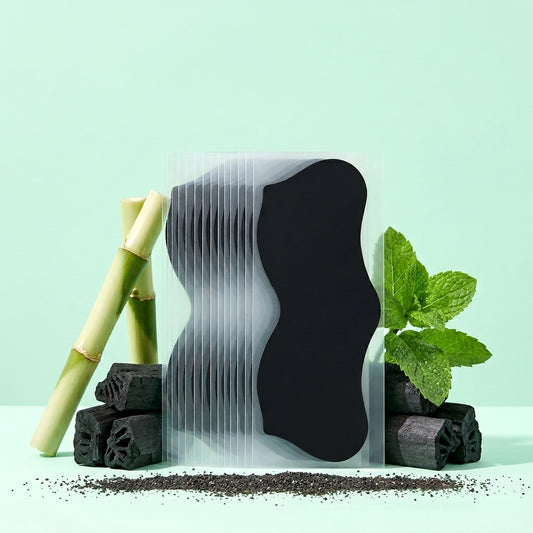 Blackhead pore strips displayed with bamboo charcoal and mint leaves, showing the deep cleansing charcoal formula.