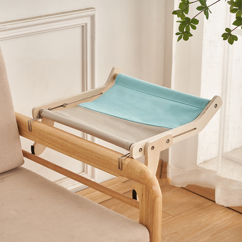Blue and gray cat hammock bed securely hanging from a wooden bed frame.