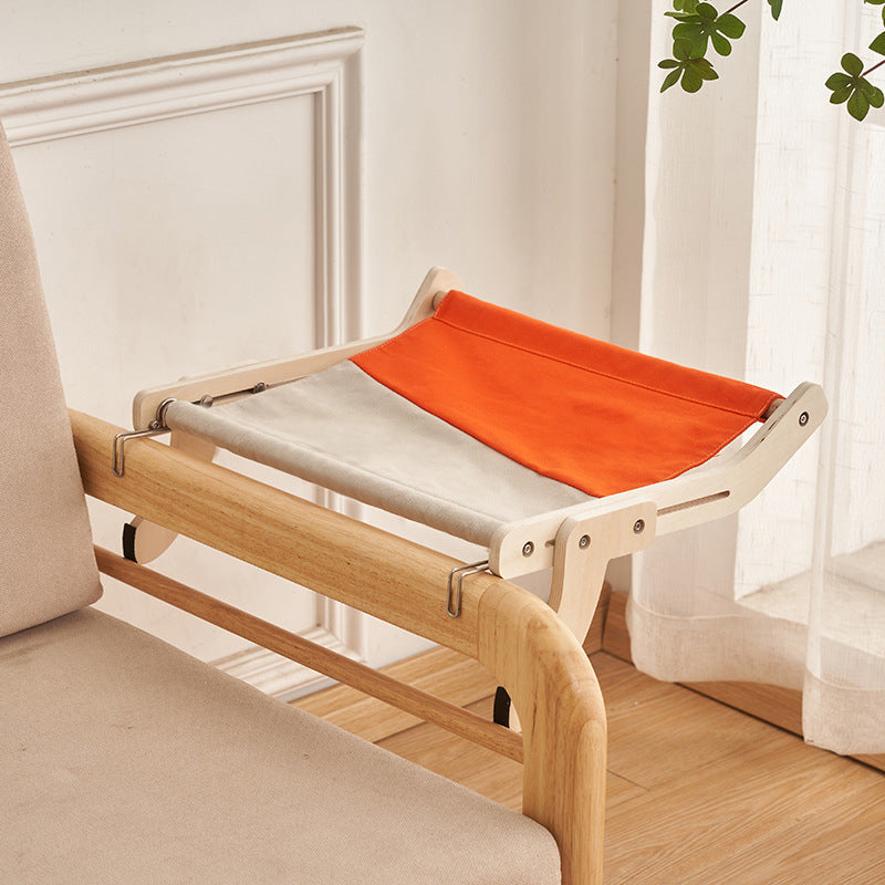 Orange and gray cat hammock bed securely hanging from a wooden bed frame.
