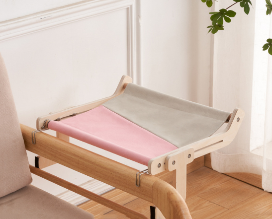 Pink and gray cat hammock bed securely hanging from a wooden bed frame.