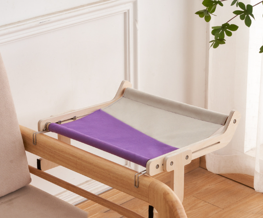 Purple and gray cat hammock bed securely hanging from a wooden bed frame.