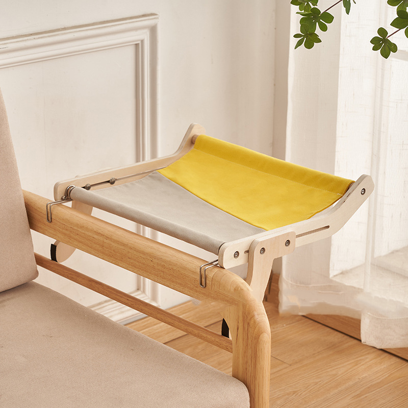 Yellow and gray cat hammock bed securely hanging from a wooden bed frame.