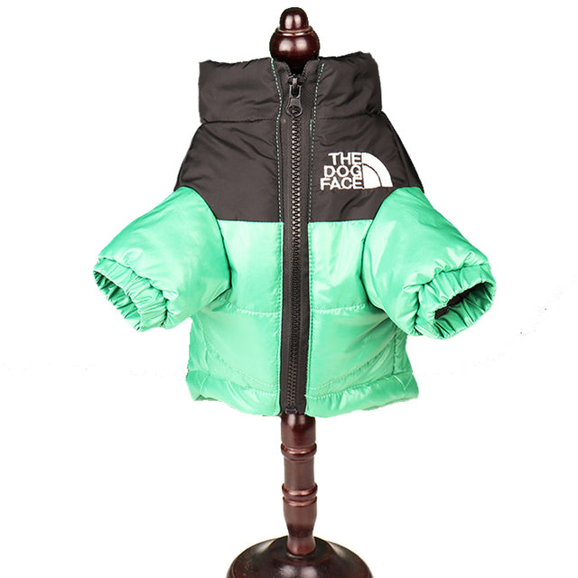 Green and black dog puffer jacket shown on a display stand, front view with zip and logo detail.