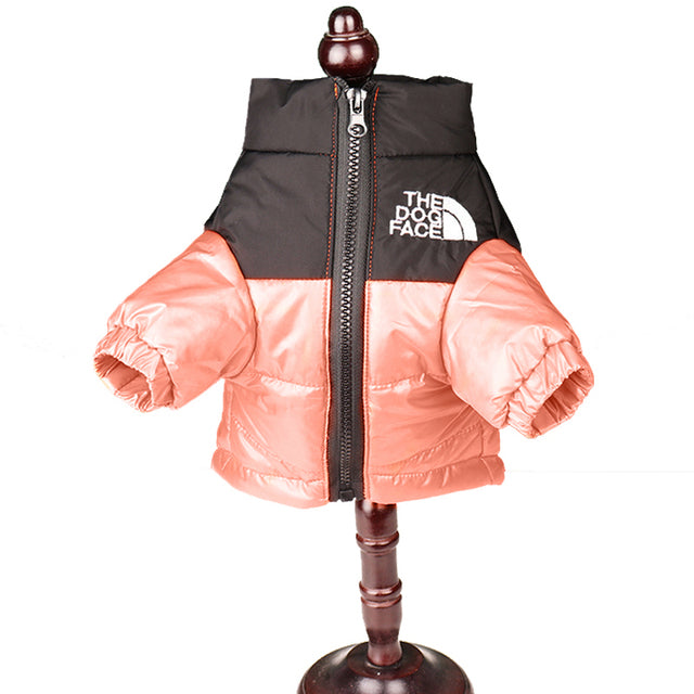 Peach and black dog puffer jacket shown on a display stand, front view with zip and logo detail.