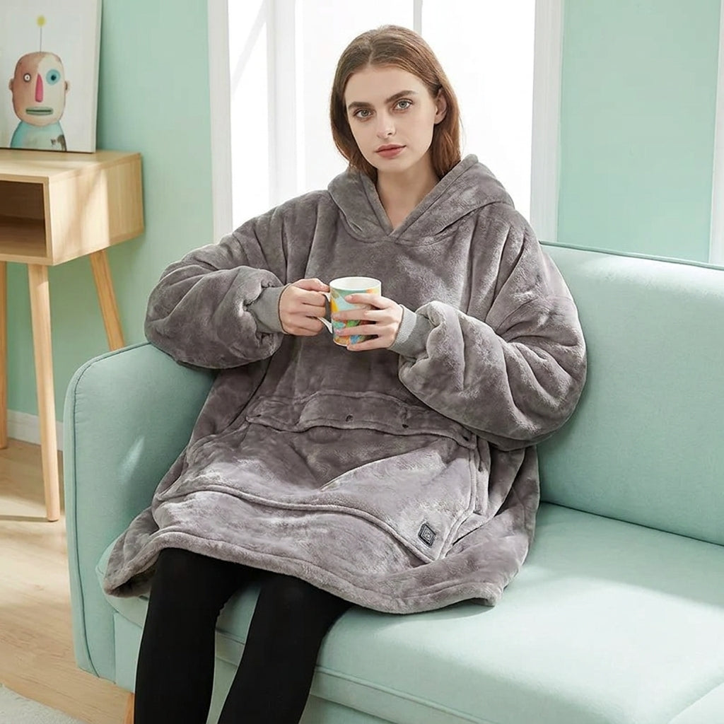 Person wearing the hooded blanket in a cosy indoor setting, showing how the oversized wearable blanket keeps you warm without restricting movement.